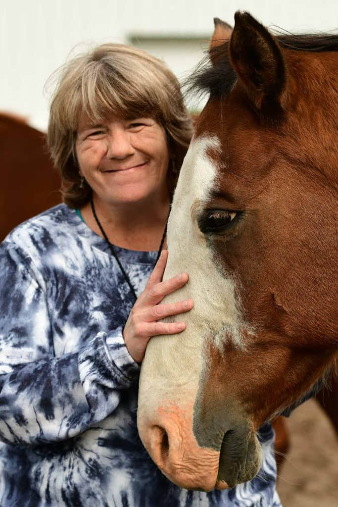 happy-mature-woman-hugging-horse
